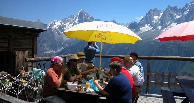 Les gens dînent en plein air avec vue sur les montagnes.