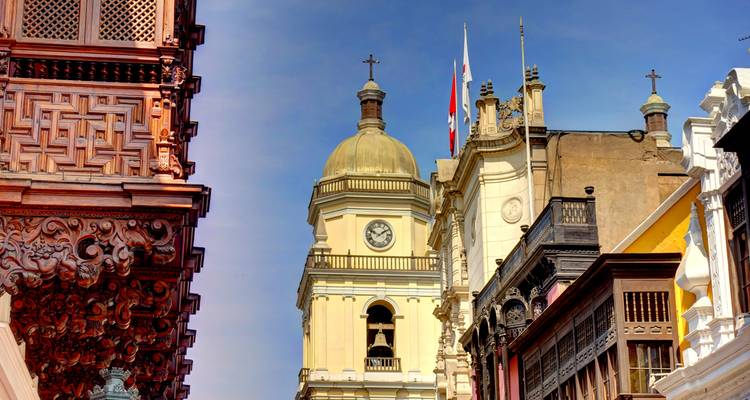 Vista de cerca de detalles arquitectónicos, incluyendo una torre de reloj y balcones de madera.