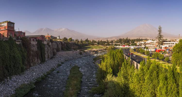 Vista panorámica de un río y montañas distantes con vegetación exuberante.