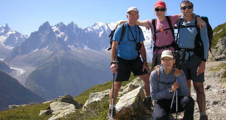 Groupe de randonneurs posant avec un paysage montagneux en arrière-plan.