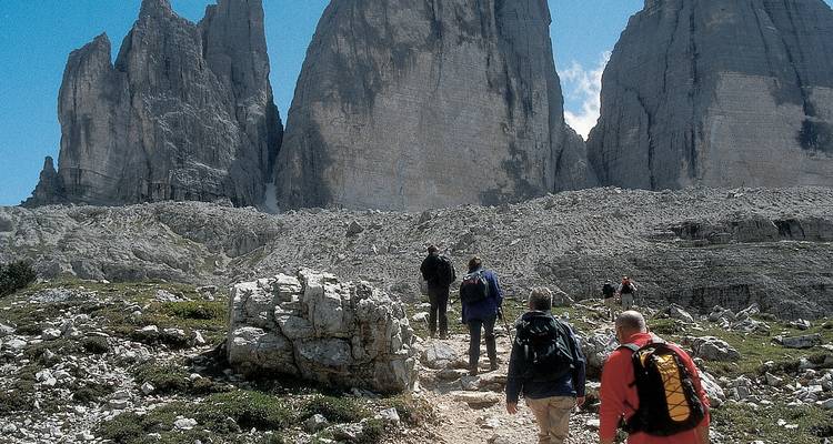 Senderistas acercándose a la formación rocosa Tre Cime di Lavaredo.