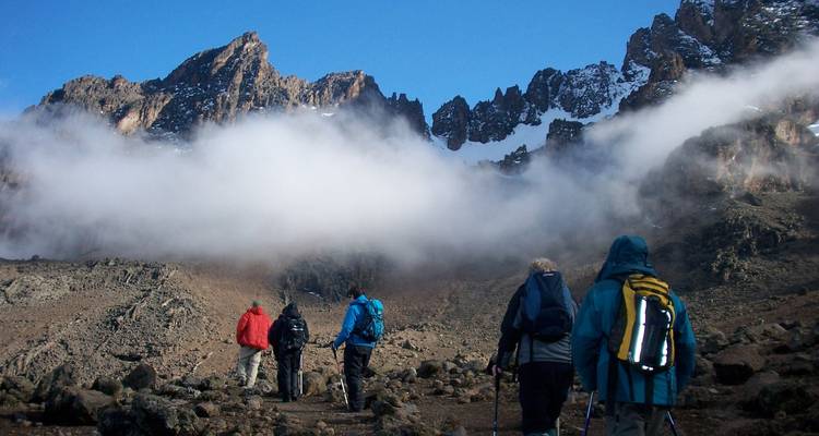 Wanderer auf dem Weg zu einem wolkenverhangenen Berg.
