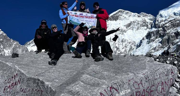 Randonneurs célébrant à un col de montagne avec un panneau.