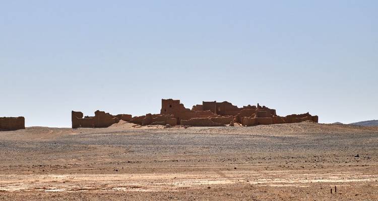 Ruines d'une structure ancienne dans un paysage désertique.