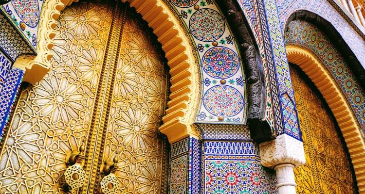 Carreaux complexes et arches sur une grande porte au Maroc.