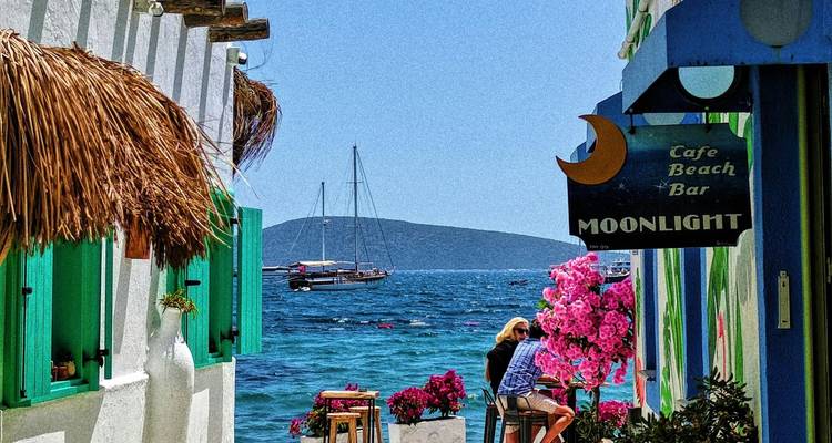 Ein Paar sitzt in einem Café mit Blick auf das Meer.