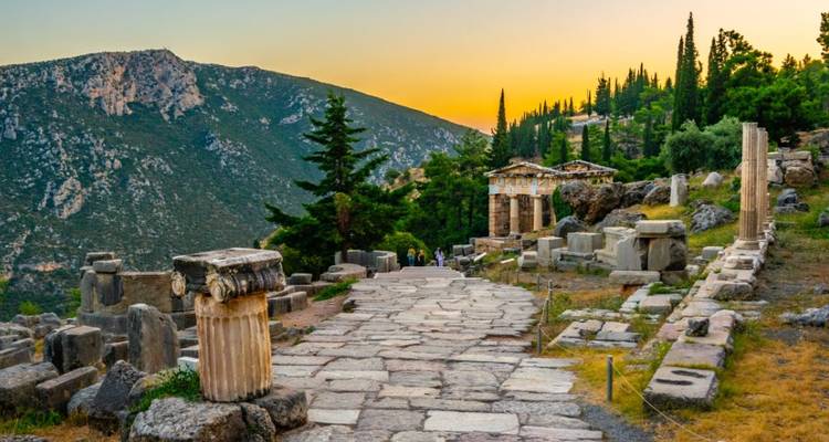 Allée de pierre ancienne avec colonnes au coucher du soleil.