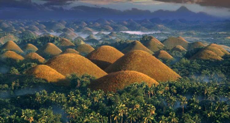 Paysage des Chocolate Hills avec une végétation luxuriante entourant des collines uniques.