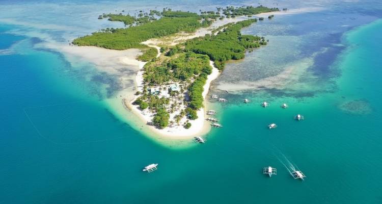 Vue aérienne d'une petite île entourée d'eaux turquoise.