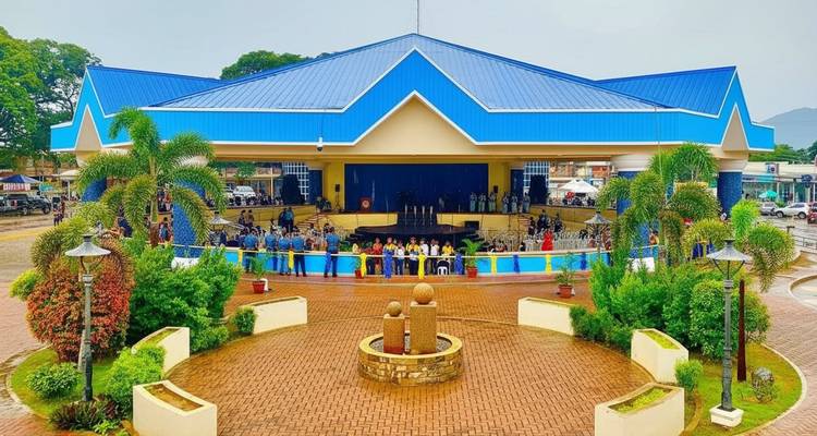 Un espace public avec une structure au toit bleu et un rassemblement de personnes.