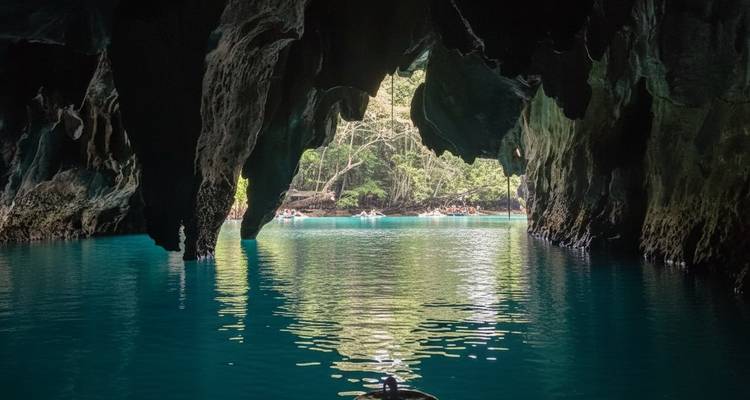 Dans une grotte avec une eau claire reflétant les formations calcaires.