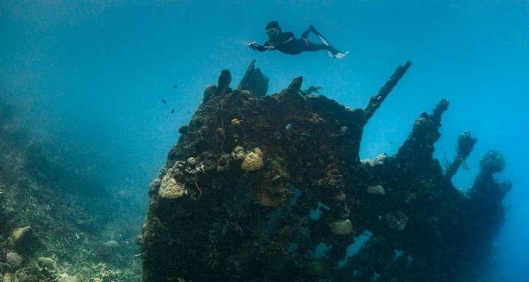 Plongeur explorant une épave sous-marine.