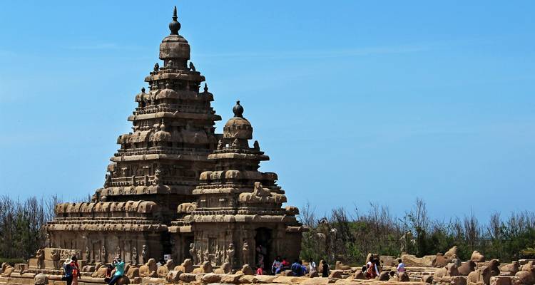 Temple ancien au bord de la mer avec des touristes en visite.