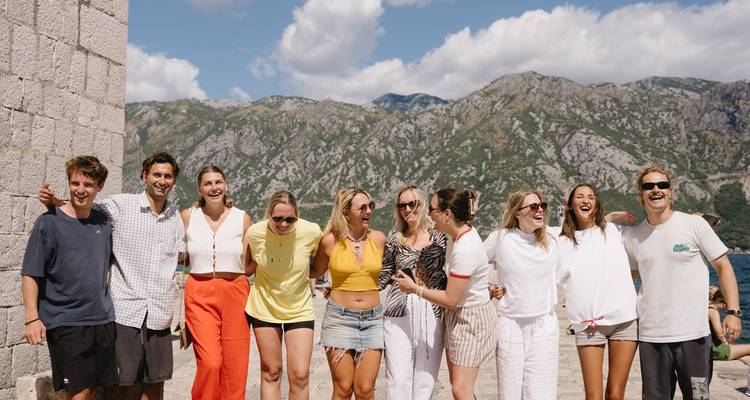 Photo de groupe avec un magnifique paysage de montagne et de mer en arrière-plan.