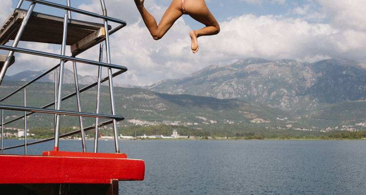 Quelqu'un qui saute dans l'eau depuis un bateau.