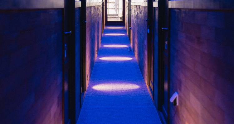 Couloir avec des motifs circulaires illuminés sur le tapis.