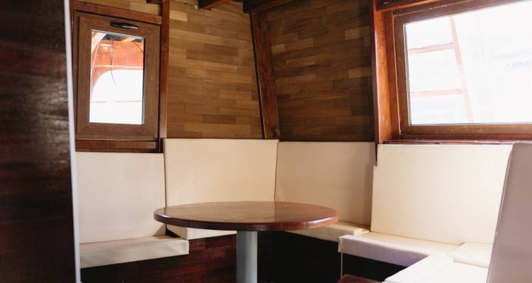 Même intérieur de cabane en bois avec une table ronde et des fenêtres.