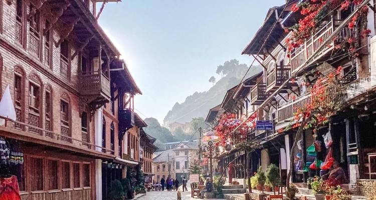 Rue charmante avec des bâtiments traditionnels et des vignes fleuries.