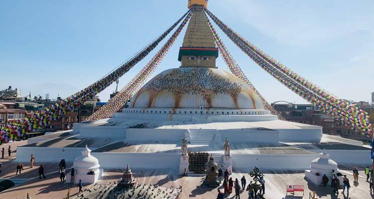 Boudhanath-Stupa mit Gebetsfahnen und umgebenden Besuchern.