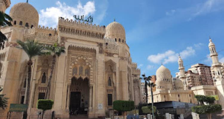 Mezquita elegante con cúpulas y minaretes bajo un cielo azul.