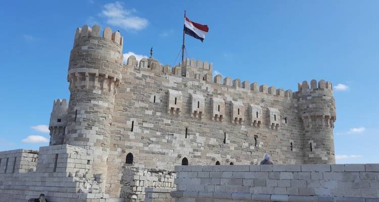 Fortaleza histórica con una bandera egipcia ondeando.