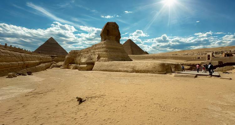 La Esfinge with pirámides en el fondo bajo un cielo soleado.
