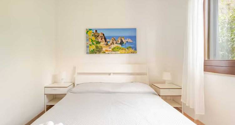 Intérieur de chambre avec une fenêtre et des œuvres d'art murales.