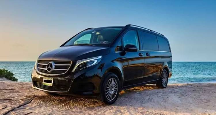 Fourgonnette Mercedes noire garée au bord de la mer.