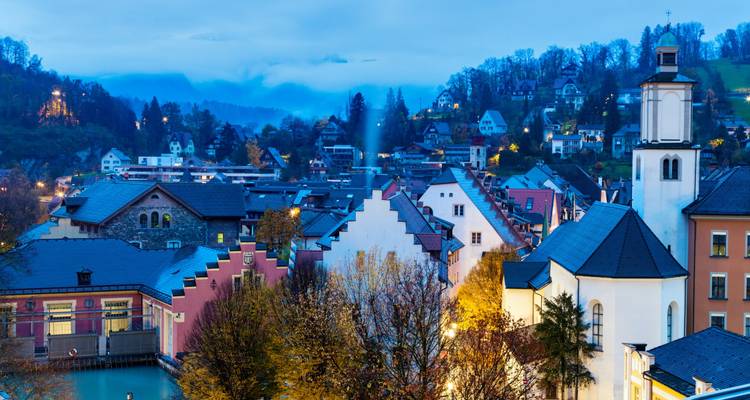 Pittoresk avondgezicht van een schilderachtig stadje met kleurrijke daken en een verlichte kerk.