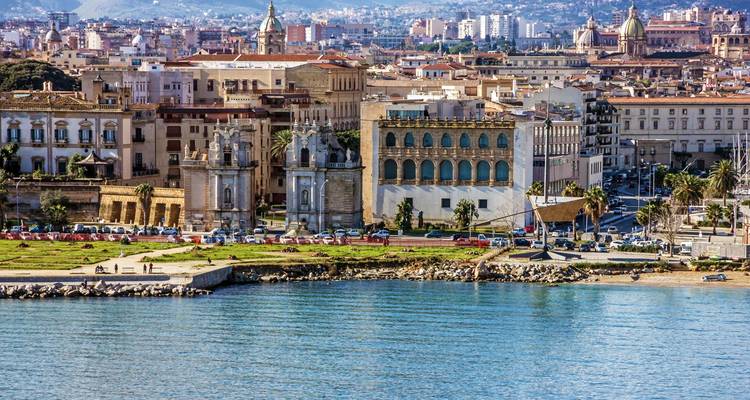 Una ciudad costera con edificios históricos a lo largo del agua bajo un cielo despejado.
