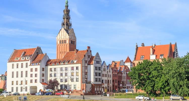 Elbląg, Pologne avec un clocher d'église proéminent et des bâtiments historiques.