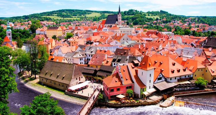 Vue panoramique de Český Krumlov avec des toits rouges et la rivière.
