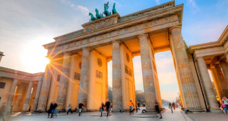 Sunburst illuminates Berlin’s Brandenburg Gate as visitors pass beneath the neoclassical columns