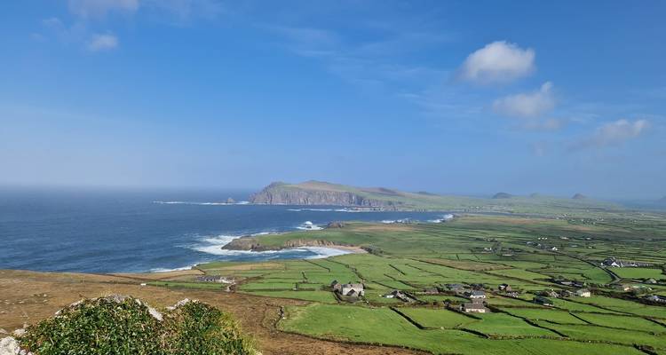 Wide coastal panorama of farmland patchwork and rugged headlands beside the Atlantic