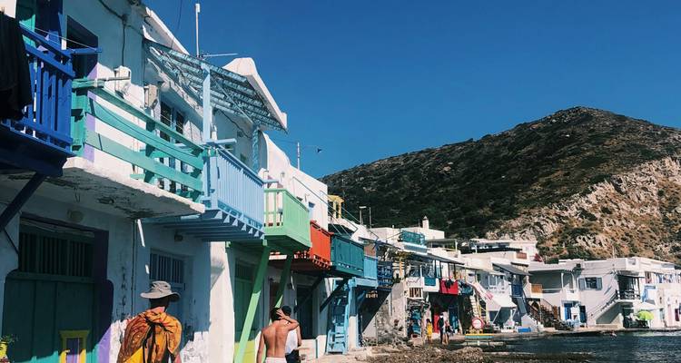 Vue côtière de maisons colorées avec des gens qui se promènent.