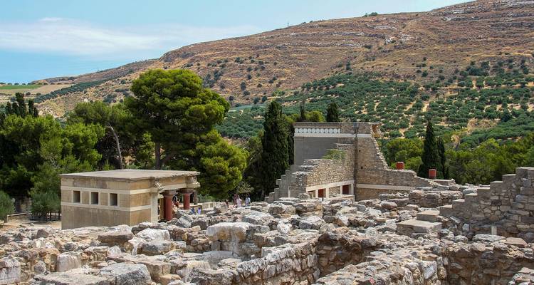 Site archéologique avec des ruines et une végétation luxuriante.