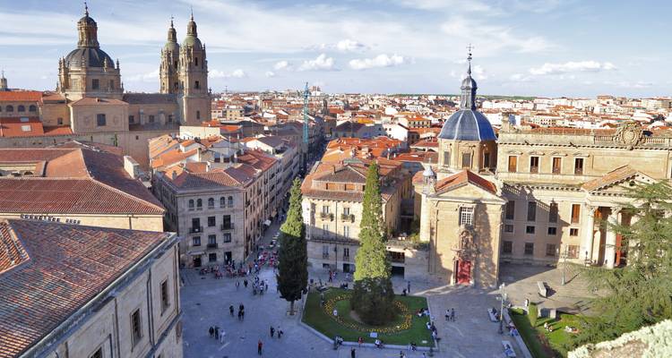 Vista aérea sobre los techos de terracota de Salamanca, las torres gemelas de la catedral y la plaza central bajo la luz del atardecer.