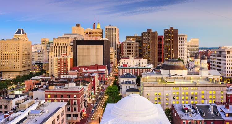 Horizonte de la ciudad con edificios históricos y modernos bajo un cielo azul.