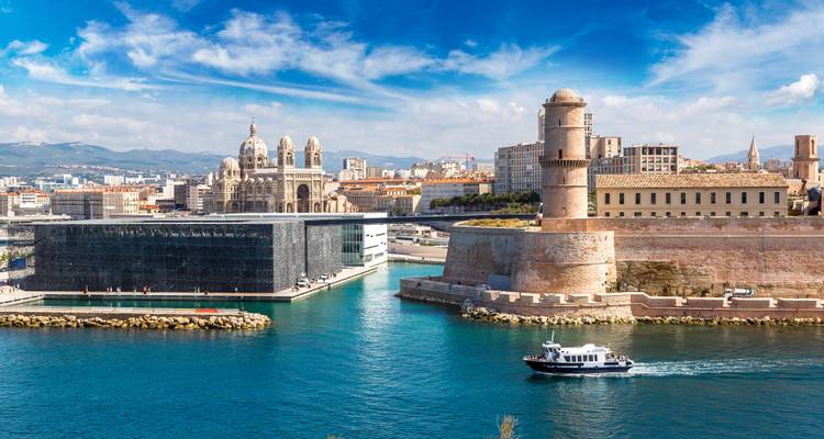 Scène portuaire expansive de Marseille mettant en vedette le Fort Saint-Jean, le MuCEM et la cathédrale sous des cieux éclatants.