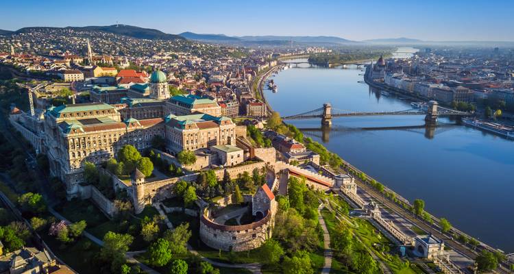 Aerial dawn view over Buda Castle, Chain Bridge and the Danube winding through Budapest.