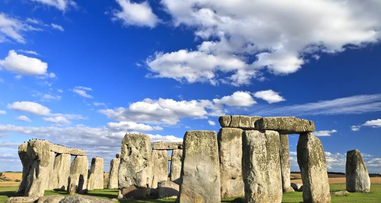 Oude stenen cirkel van Stonehenge onder een dramatische blauwe hemel met verspreide wolken