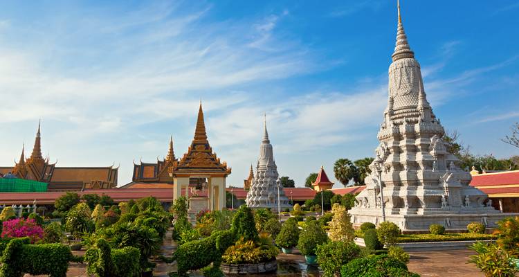 Jardines y estupas del Palacio Real de Phnom Penh bañados en la cálida luz del sol de la tarde.