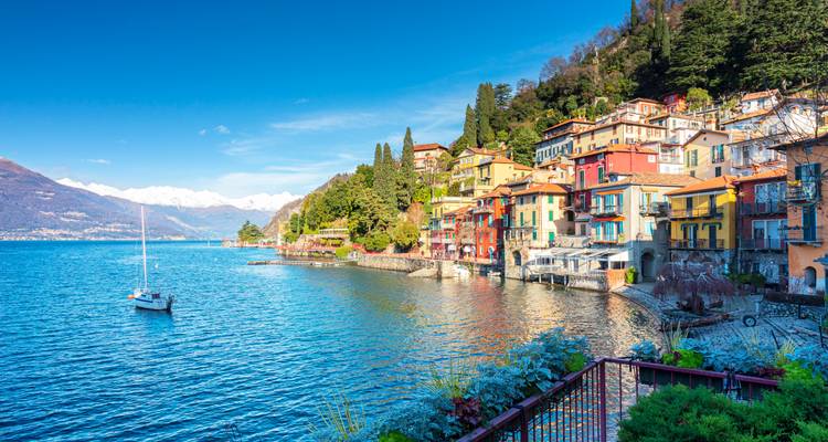 Colorido pueblo de Varenna bordeando la orilla del resplandeciente Lago Como con los Alpes nevados en la distancia.