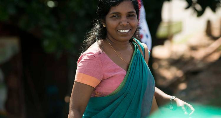 Femme locale souriante en sari coloré regarde vers la caméra dans une douce lumière du jour