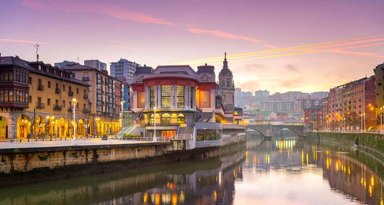 Une vue surplombant une rivière avec le magnifique marché de La Ribera à Bilbao, en Espagne, au coucher du soleil.