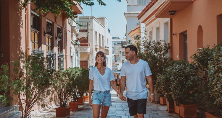 Pareja caminando por una calle pintoresca en Plaka.