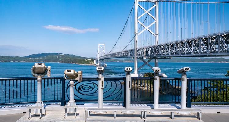 Binocular stands overlook the sweeping Onaruto Bridge spanning blue straits and distant hills.