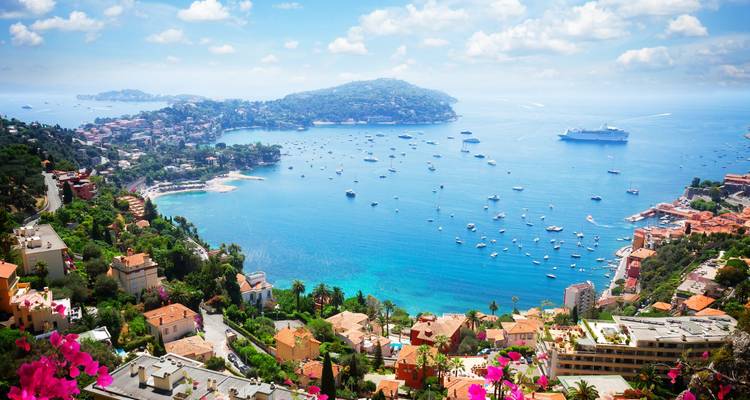 Sparkling azure bay of the French Riviera with hillside villas, yachts and cruise ship.