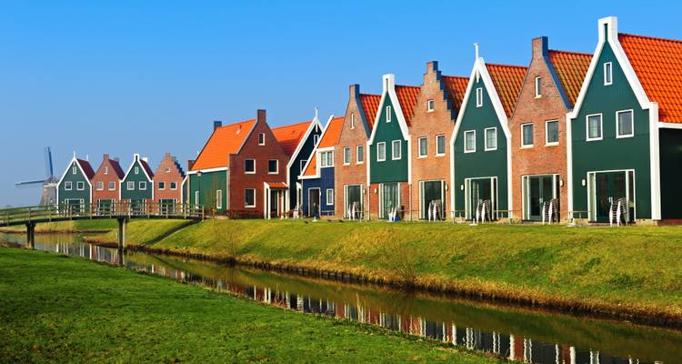 Maisons traditionnelles néerlandaises avec reflets dans un canal.