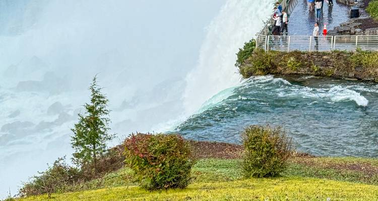 Des visiteurs regardant les chutes du Niagara depuis une passerelle.